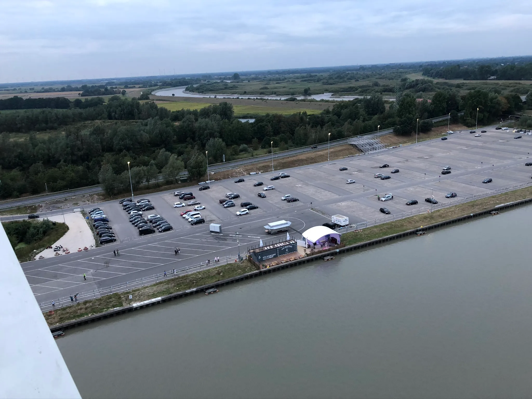 Luftaufnahme der Festfläche neben der Werft, noch als Parkplatz mit Autos