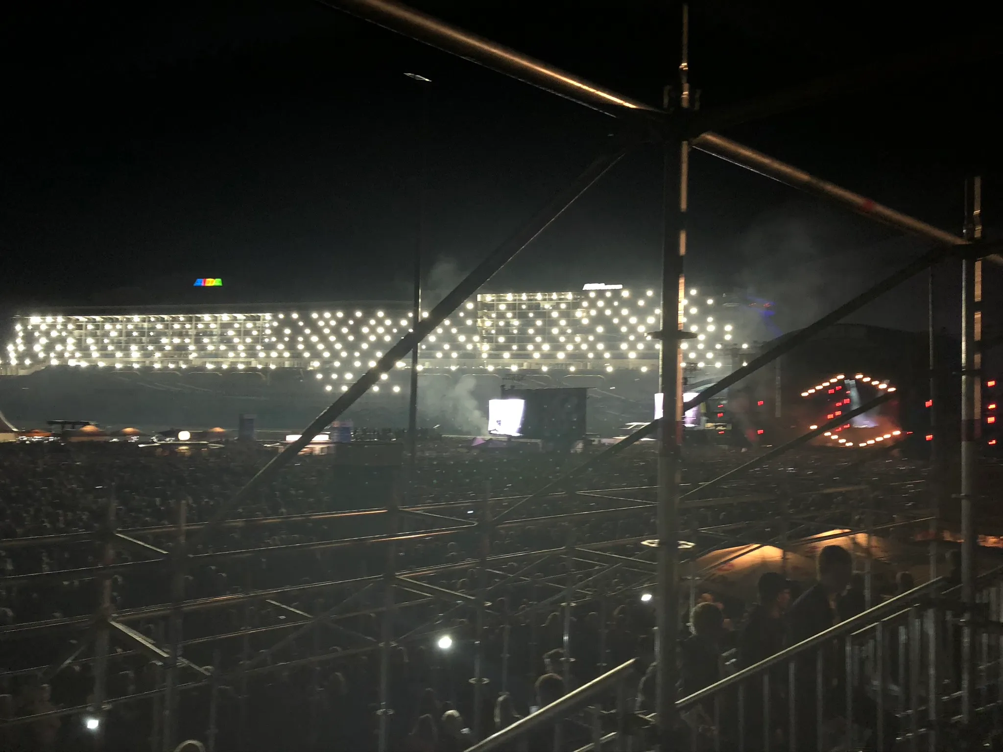 Taufnacht: Zuschauer vor der hell erleuchteten AIDAnova, weiße Lichtpunkte über das ganze Schiff verteilt