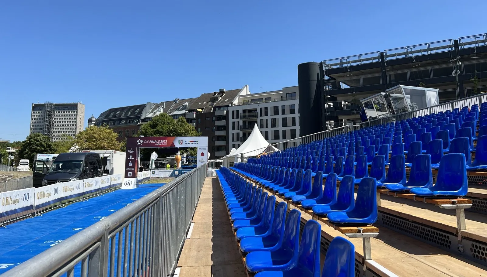 Zuschauer-Tribüne mit blauen Sitzplätzen an einer Wettkampfstrecke