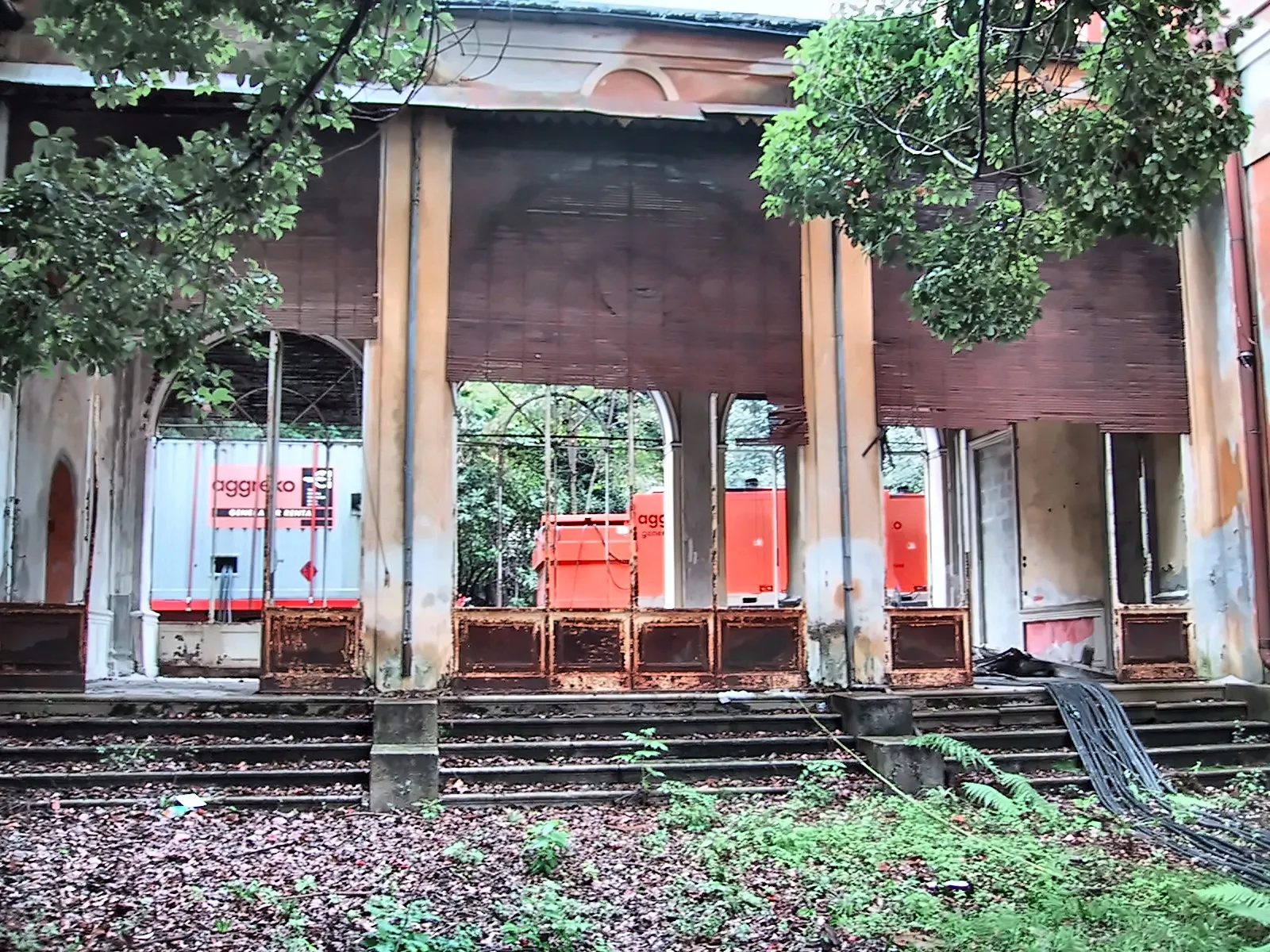 Verfallene Kolonnade einer alten Villa, dahinter rote Stromgeneratoren für die Veranstaltung